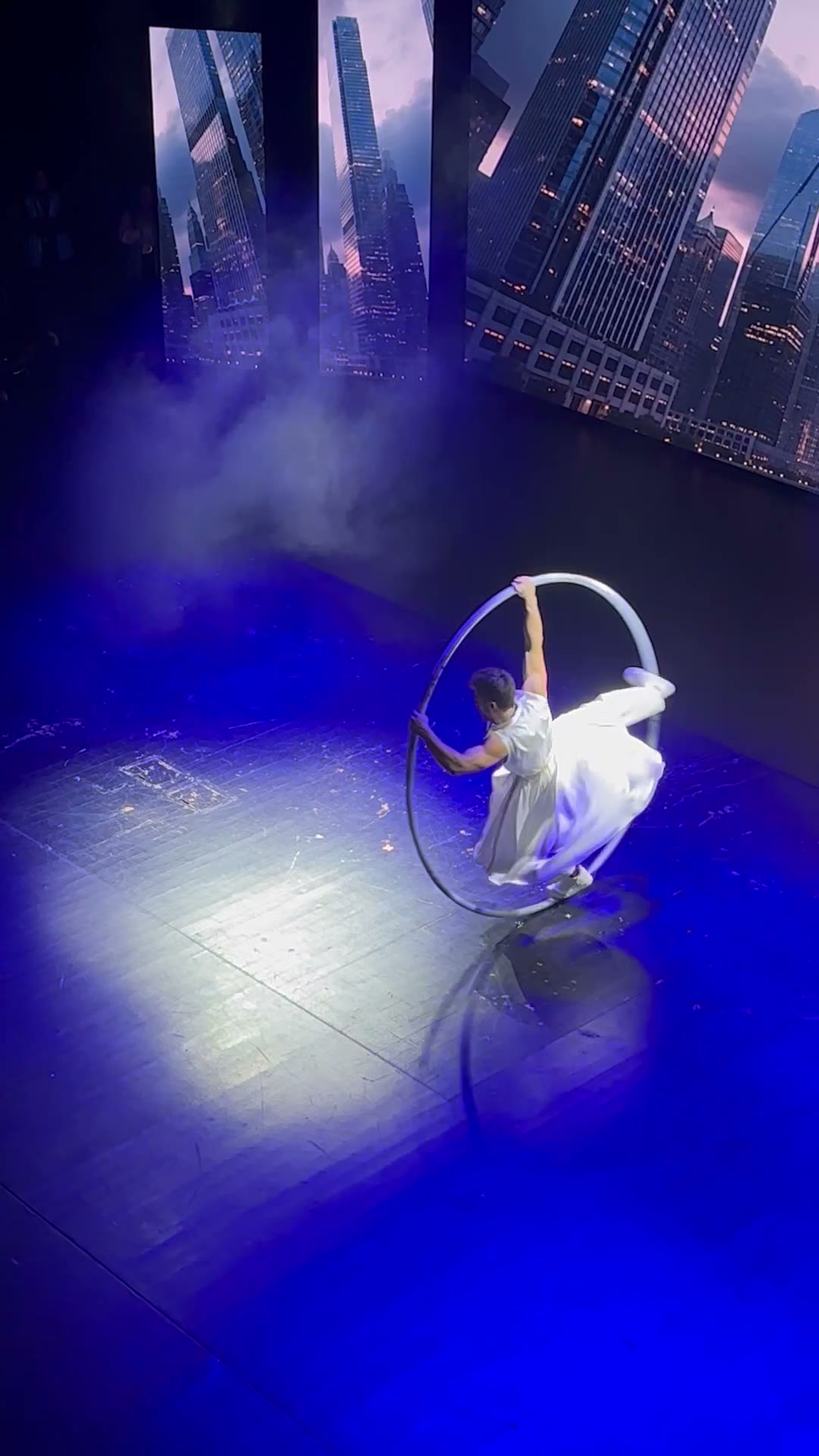 Sis ve spot ışığı altında Cyr Wheel figürü