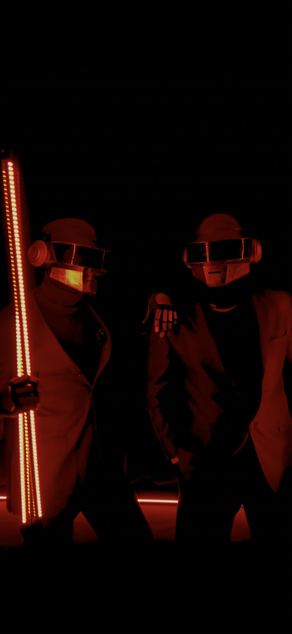 Karanlık sahnede kırmızı LED çomaklarla ikili Daft Punk karakteri